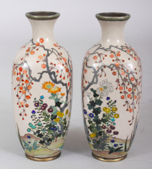 AN UNUSUAL MIRROR PAIR OF JAPANESE MEIJI PERIOD SILVER WIRE CLOISONNE & GIN BARI BEIGE GROUND CLOISONNE VASES, each decorated in fine detail with a continuous riverbank scene of flowers and overhanging blossoms, 5.1in high.