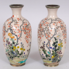 AN UNUSUAL MIRROR PAIR OF JAPANESE MEIJI PERIOD SILVER WIRE CLOISONNE & GIN BARI BEIGE GROUND CLOISONNE VASES, each decorated in fine detail with a continuous riverbank scene of flowers and overhanging blossoms, 5.1in high.