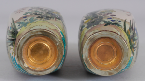 AN UNUSUAL MIRROR PAIR OF JAPANESE MEIJI PERIOD SILVER WIRE CLOISONNE & GIN BARI BEIGE GROUND CLOISONNE VASES, each decorated in fine detail with a continuous riverbank scene of flowers and overhanging blossoms, 5.1in high.