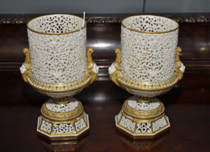 Pair of Grainger & Co. pot pourri vases, each of urn form with bodies, bases and plinths pierced with tracery, female head form handles and gilt detailing with blue enamel jewelled studding, height 21cm, printed factory mark to bases, inscribed