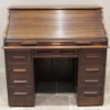 An early 20th century oak roll top desk