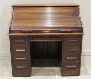 An early 20th century oak roll top desk