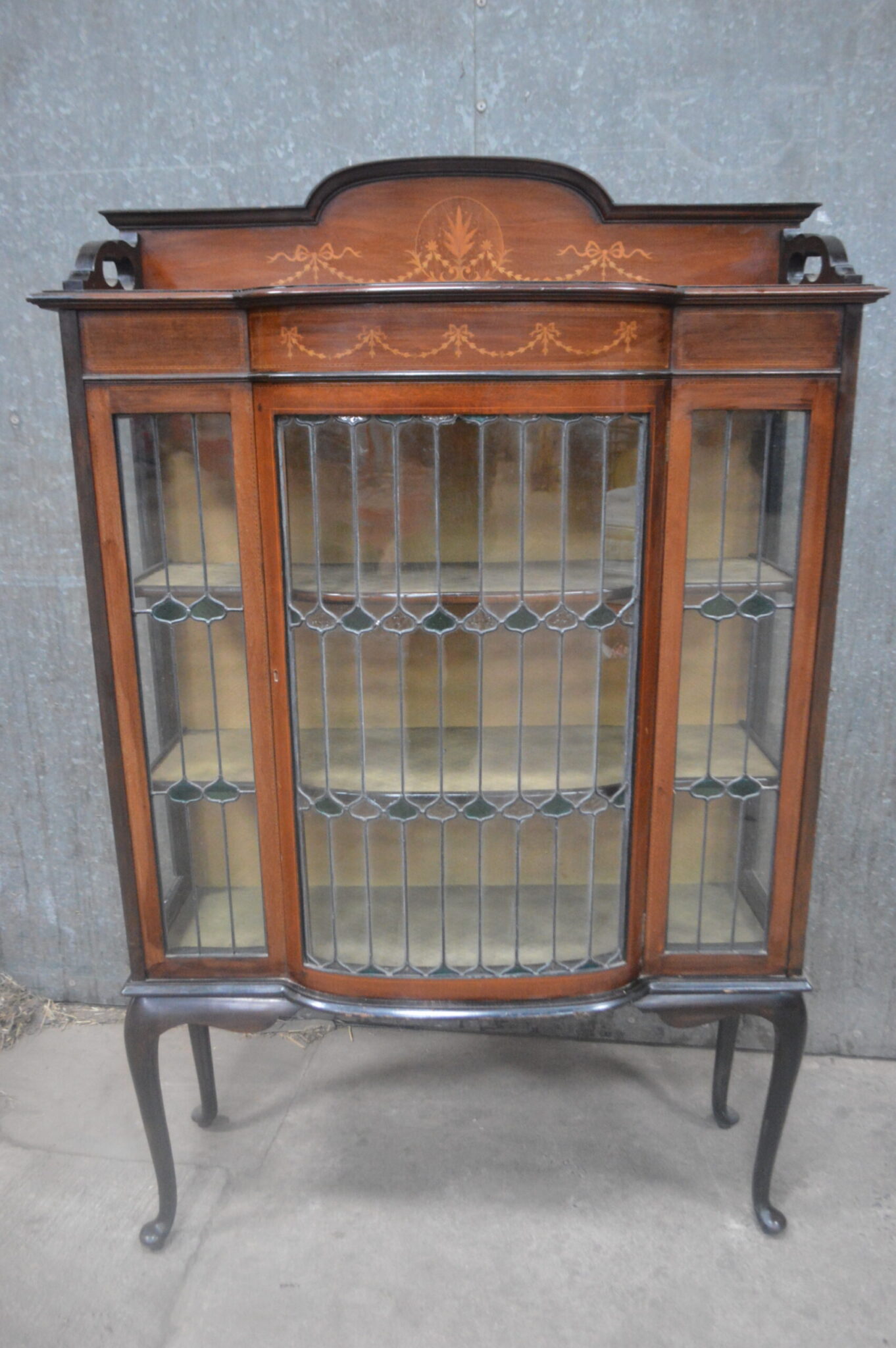A nice quality Edwardian bow front lead, and stained glass satinwood inlaid display cabinet Raised on carbide legs.