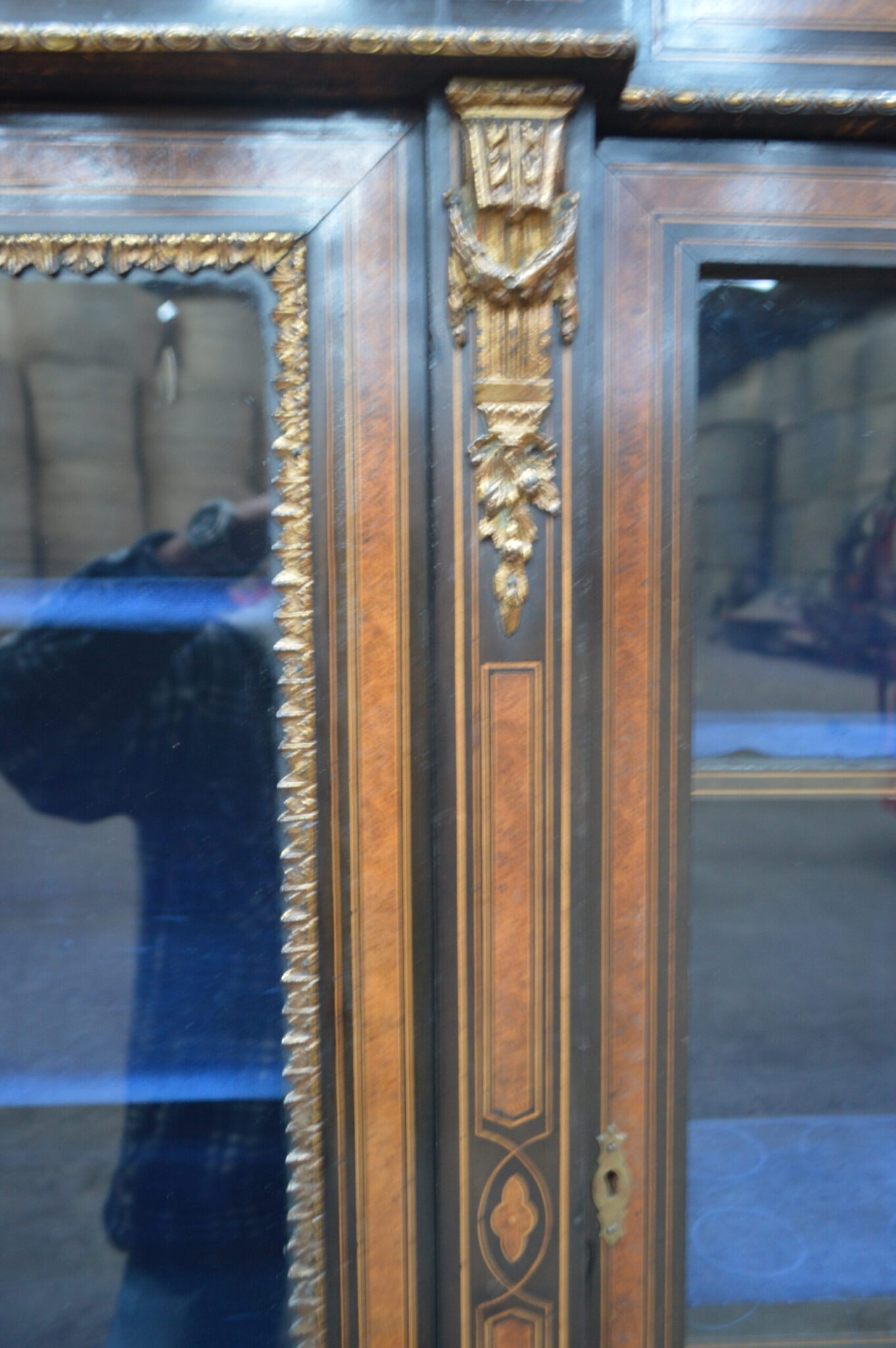 A Victorian amboyna and inlaid ebonised three-door breakfront bookcase.