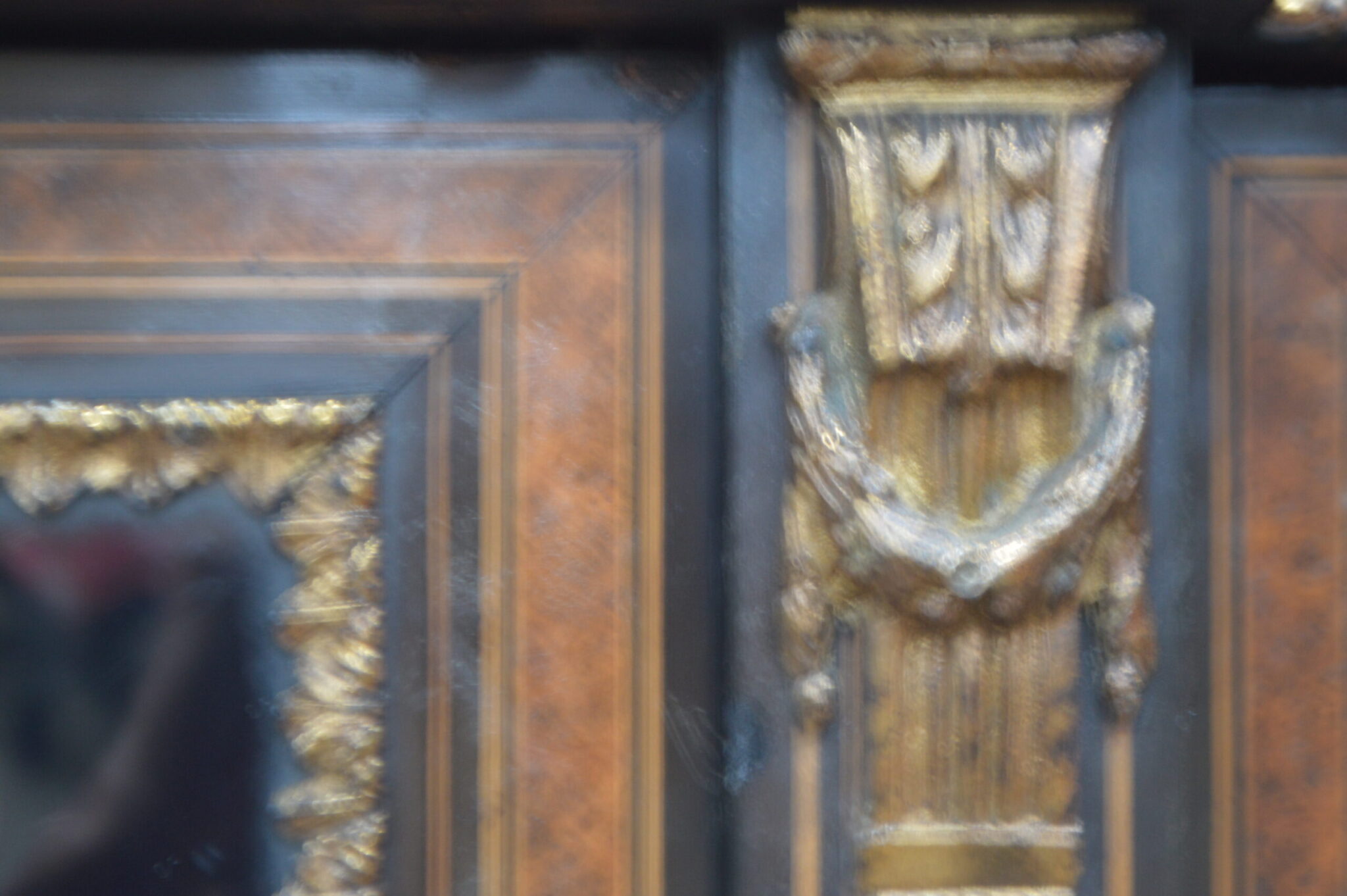 A Victorian amboyna and inlaid ebonised three-door breakfront bookcase.